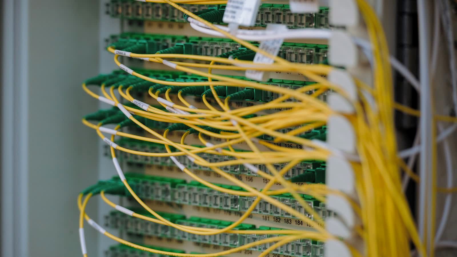 Yellow and green network cables patched into a server rack