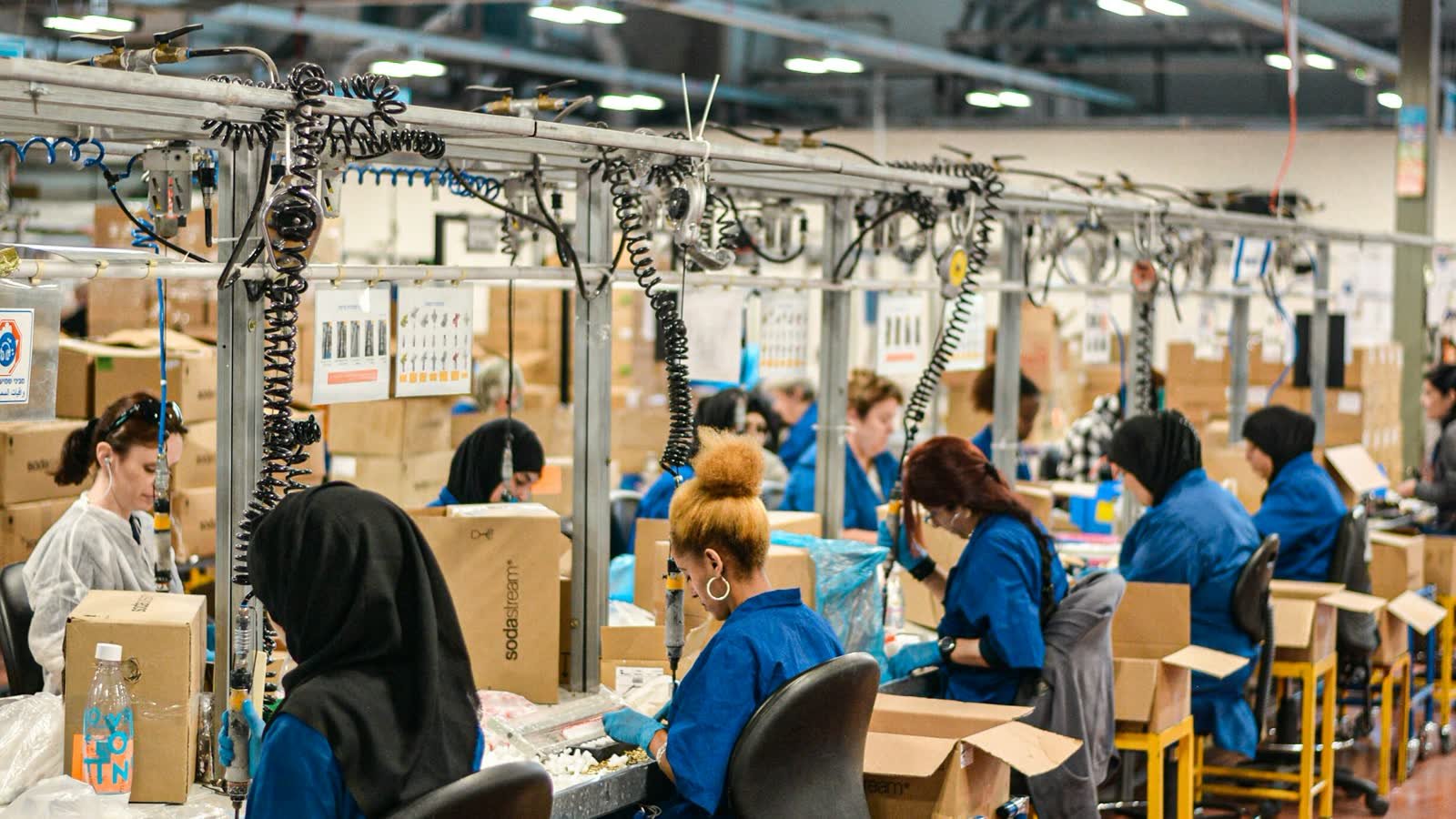 Workers packing goods along a factory assembly line