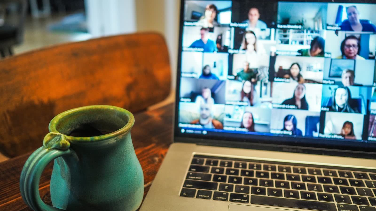 A laptop screen showing a grid of people on a video call